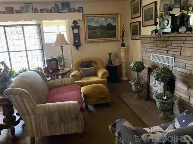 sitting room featuring a stone fireplace