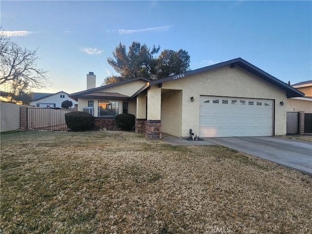 ranch-style home with a yard and a garage