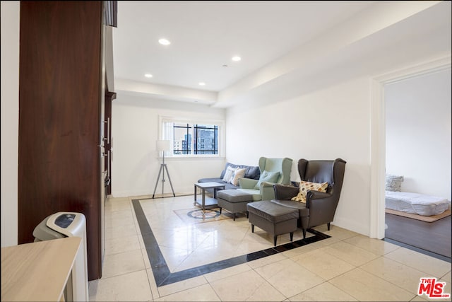 tiled living room featuring a tray ceiling