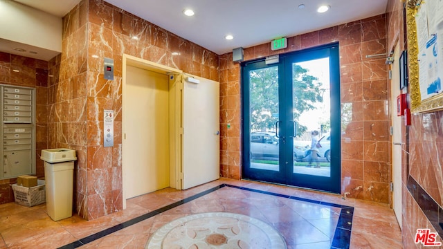 doorway to outside with tile walls, french doors, and mail boxes