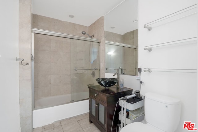 full bathroom with tile patterned flooring, combined bath / shower with glass door, sink, and toilet