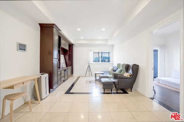 living room featuring light tile patterned floors and a tray ceiling