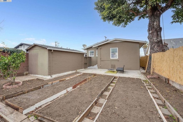 back of house featuring a patio and a shed