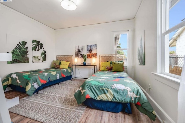 bedroom with multiple windows and hardwood / wood-style floors