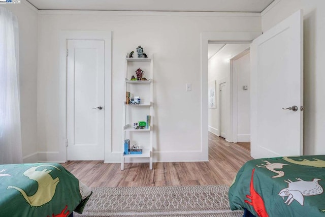 bedroom featuring ornamental molding and wood-type flooring