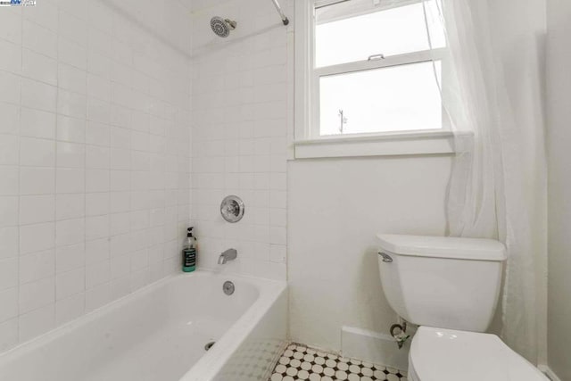 bathroom with tiled shower / bath and toilet