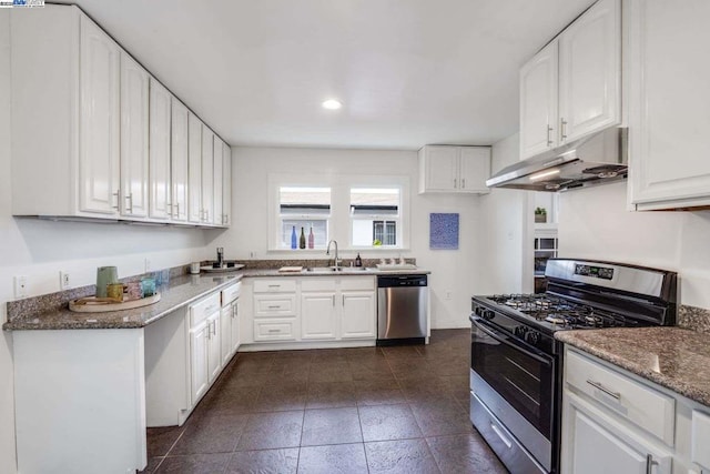 kitchen featuring white cabinetry, appliances with stainless steel finishes, sink, and dark stone counters