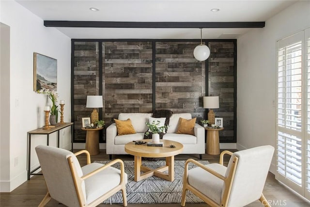 sitting room featuring beam ceiling, dark wood-type flooring, and a wealth of natural light