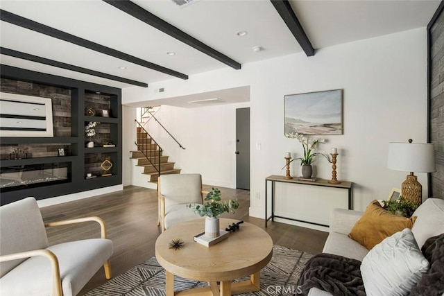 living room featuring built in shelves, a fireplace, dark hardwood / wood-style floors, and beamed ceiling