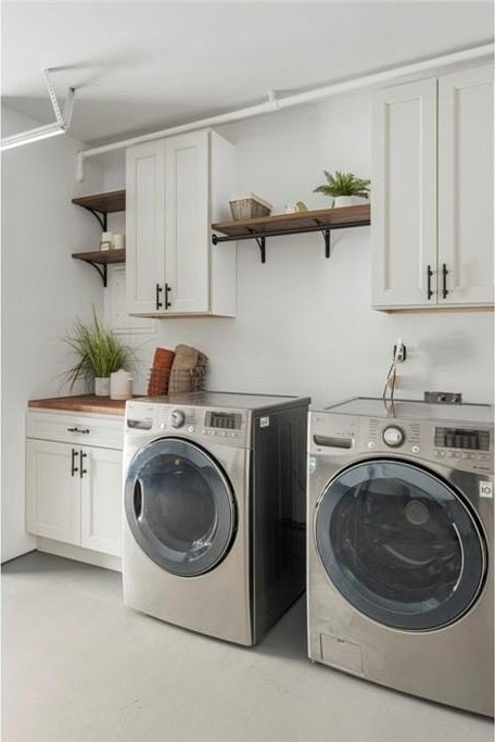 washroom featuring cabinets and washing machine and clothes dryer