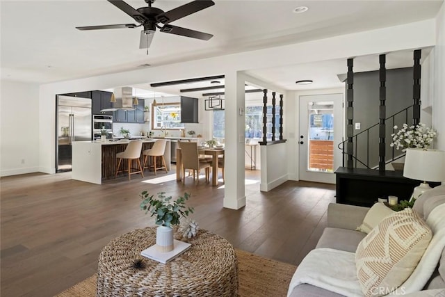 living room featuring ceiling fan and dark hardwood / wood-style floors