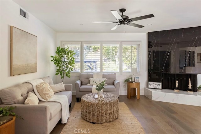 living room featuring hardwood / wood-style floors and ceiling fan