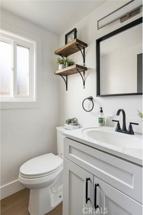 bathroom featuring hardwood / wood-style flooring, vanity, and toilet