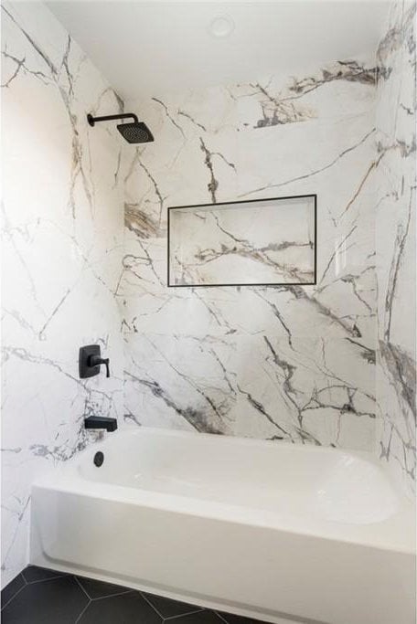 bathroom featuring tiled shower / bath combo and tile patterned flooring