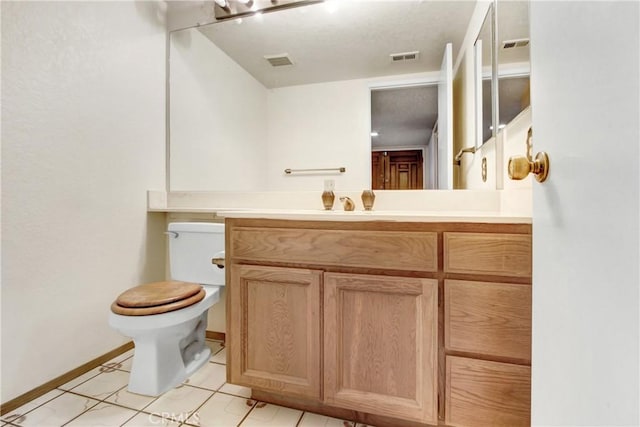 bathroom featuring vanity, toilet, and tile patterned flooring