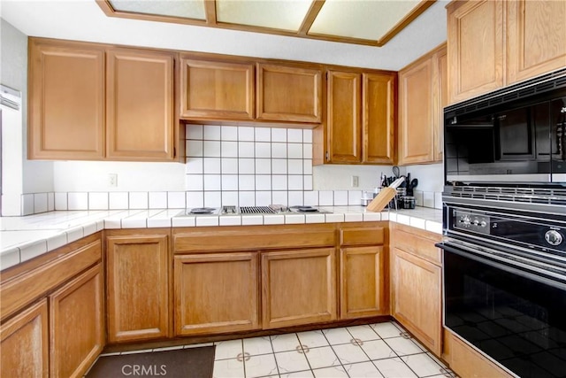 kitchen with tile countertops and black appliances