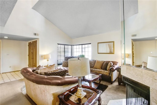 carpeted living room featuring high vaulted ceiling and a tile fireplace