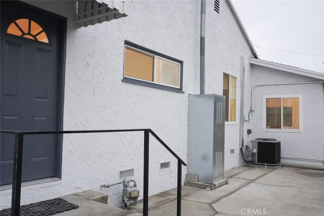 entrance to property with a patio area and central air condition unit