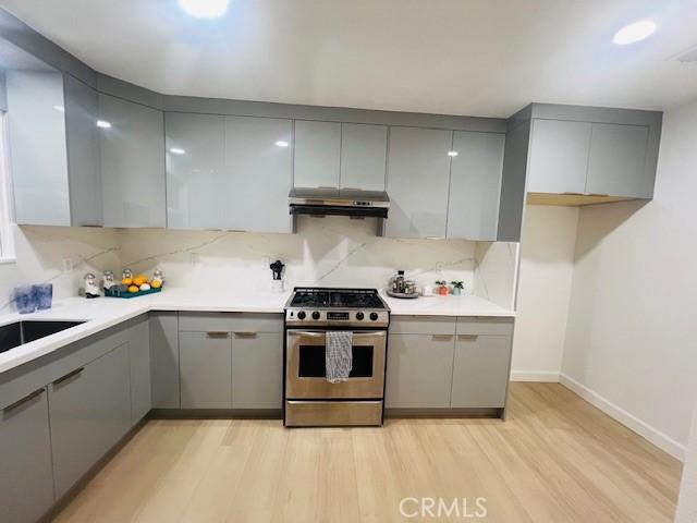 kitchen featuring stainless steel range with gas cooktop and gray cabinets