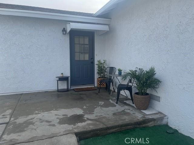 view of exterior entry with a patio area