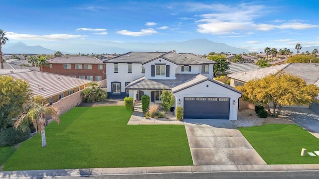 view of front of house with a garage, a mountain view, and a front lawn