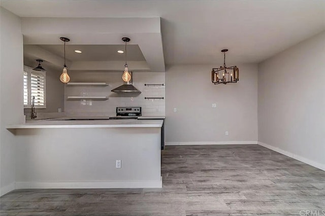 kitchen with stainless steel electric range oven, wood-type flooring, decorative backsplash, and decorative light fixtures