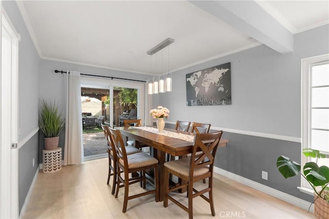 dining space with beam ceiling, crown molding, and light hardwood / wood-style flooring