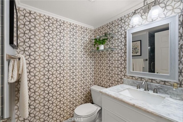 bathroom with crown molding, vanity, and toilet