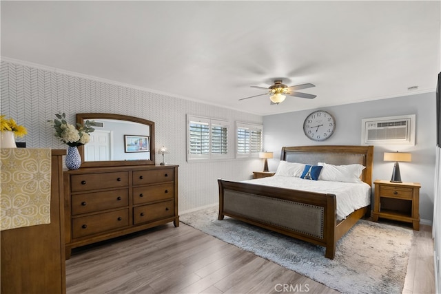 bedroom featuring crown molding, a wall mounted air conditioner, ceiling fan, and light hardwood / wood-style flooring