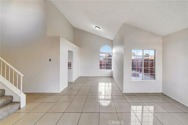 tiled spare room with high vaulted ceiling