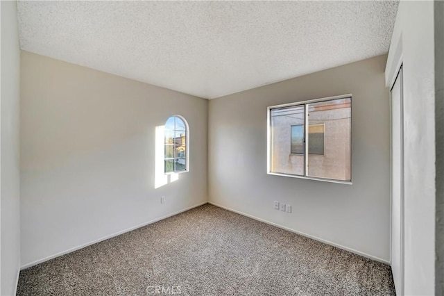 carpeted spare room featuring a textured ceiling