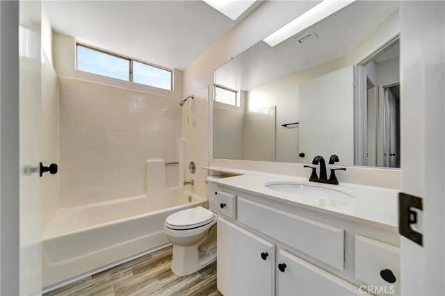 full bathroom featuring vanity, hardwood / wood-style floors, shower / bathtub combination, and toilet