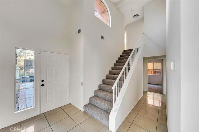 tiled entryway with a towering ceiling