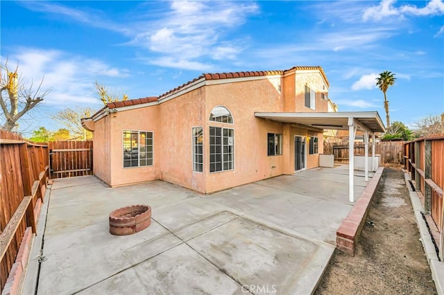 rear view of house with a patio area and a fire pit