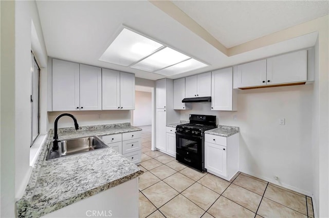 kitchen with light tile patterned flooring, sink, light stone counters, black gas range oven, and white cabinets