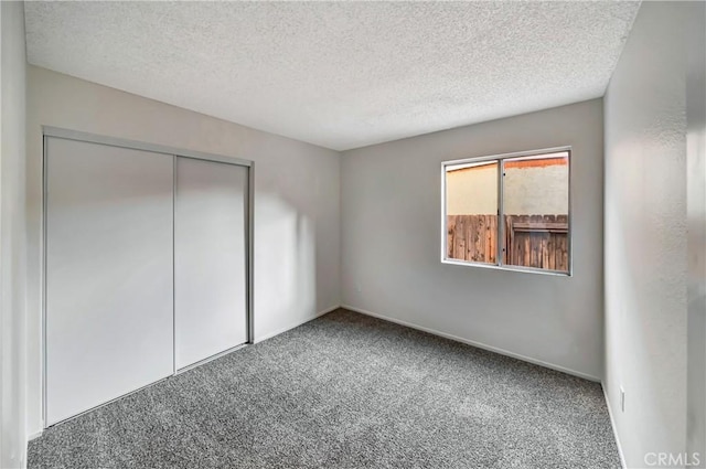 unfurnished bedroom featuring carpet flooring, a closet, and a textured ceiling