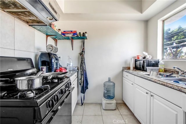 kitchen featuring white cabinetry, sink, light tile patterned floors, light stone counters, and black appliances