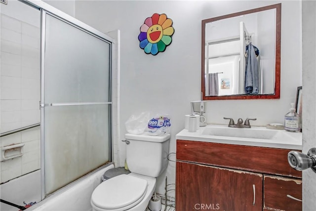 full bathroom featuring vanity, bath / shower combo with glass door, and toilet