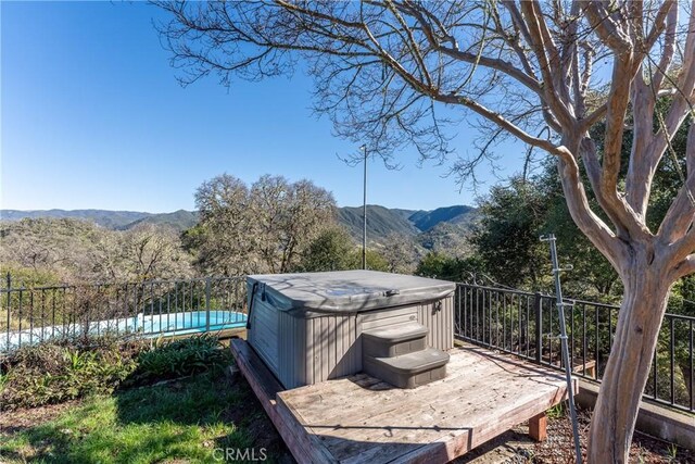 exterior space with a mountain view and a hot tub