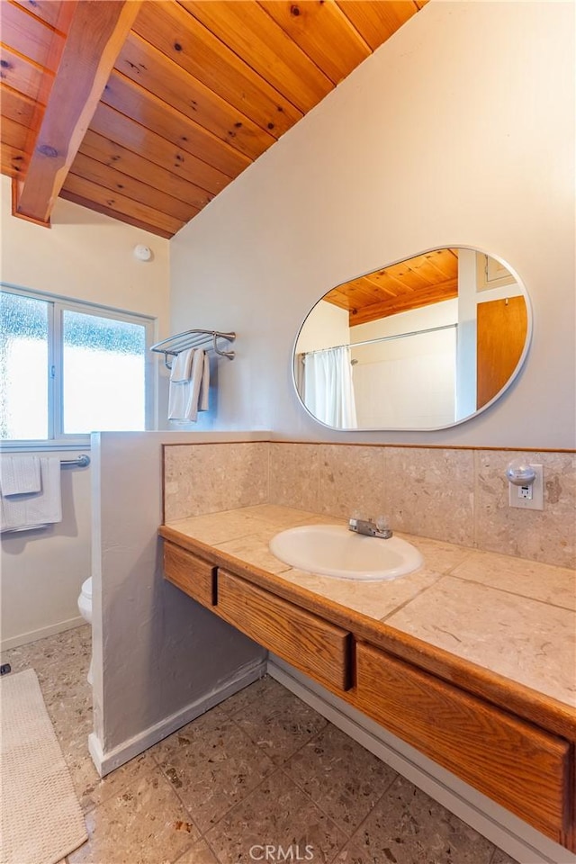 bathroom with tasteful backsplash, toilet, lofted ceiling, wood ceiling, and sink