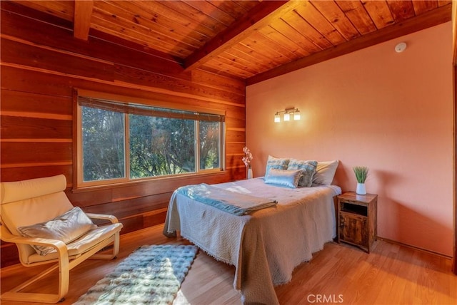 bedroom with wooden walls, beam ceiling, and wooden ceiling