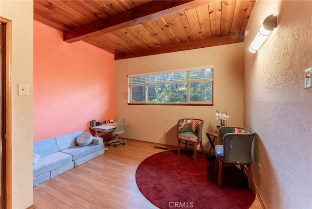 sitting room with light hardwood / wood-style floors, beamed ceiling, and wood ceiling