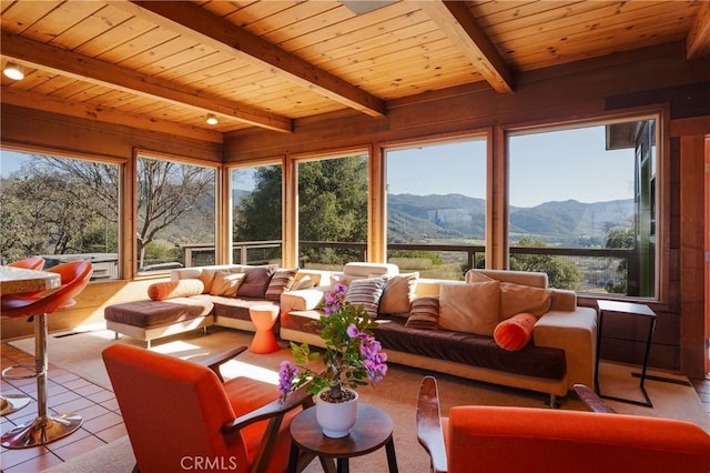 sunroom / solarium with a mountain view, wood ceiling, and a healthy amount of sunlight