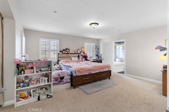 bedroom featuring connected bathroom and light colored carpet