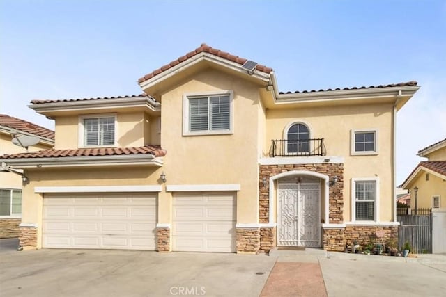 mediterranean / spanish-style house with a balcony and a garage