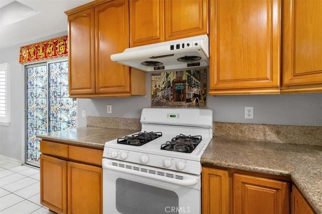 kitchen with white gas stove and light tile patterned floors