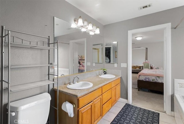 bathroom with a tub to relax in, tile patterned floors, and vanity