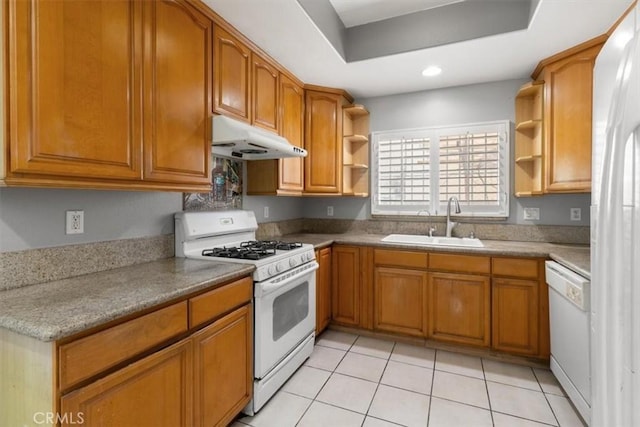 kitchen with light tile patterned flooring, white appliances, a tray ceiling, and sink