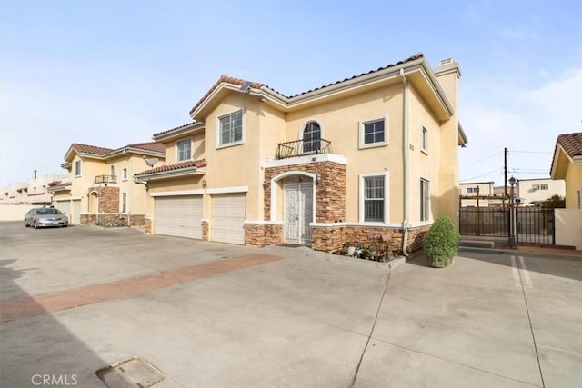 mediterranean / spanish home with a garage and a balcony