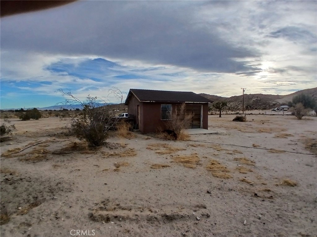 view of outbuilding featuring a garage, a mountain view, and a rural view